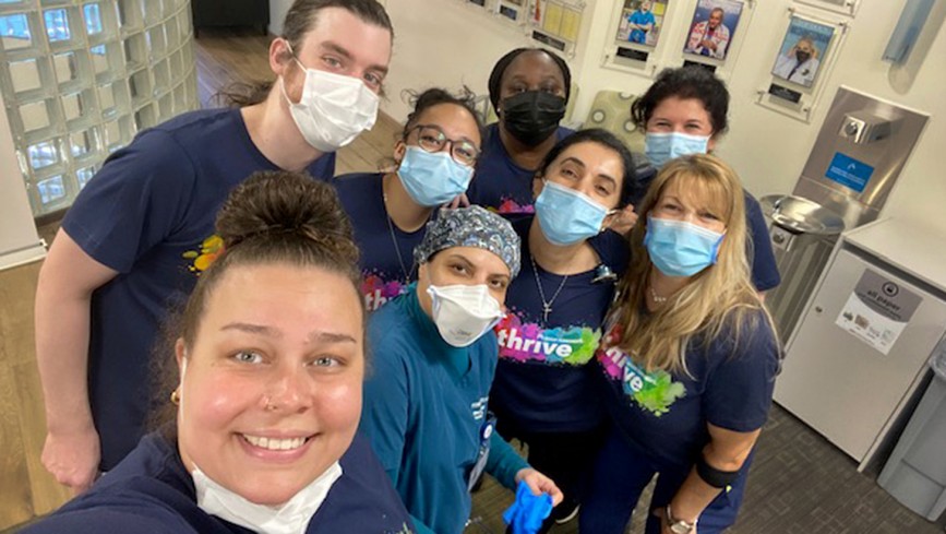 A group of health care workers, looking up and smiling