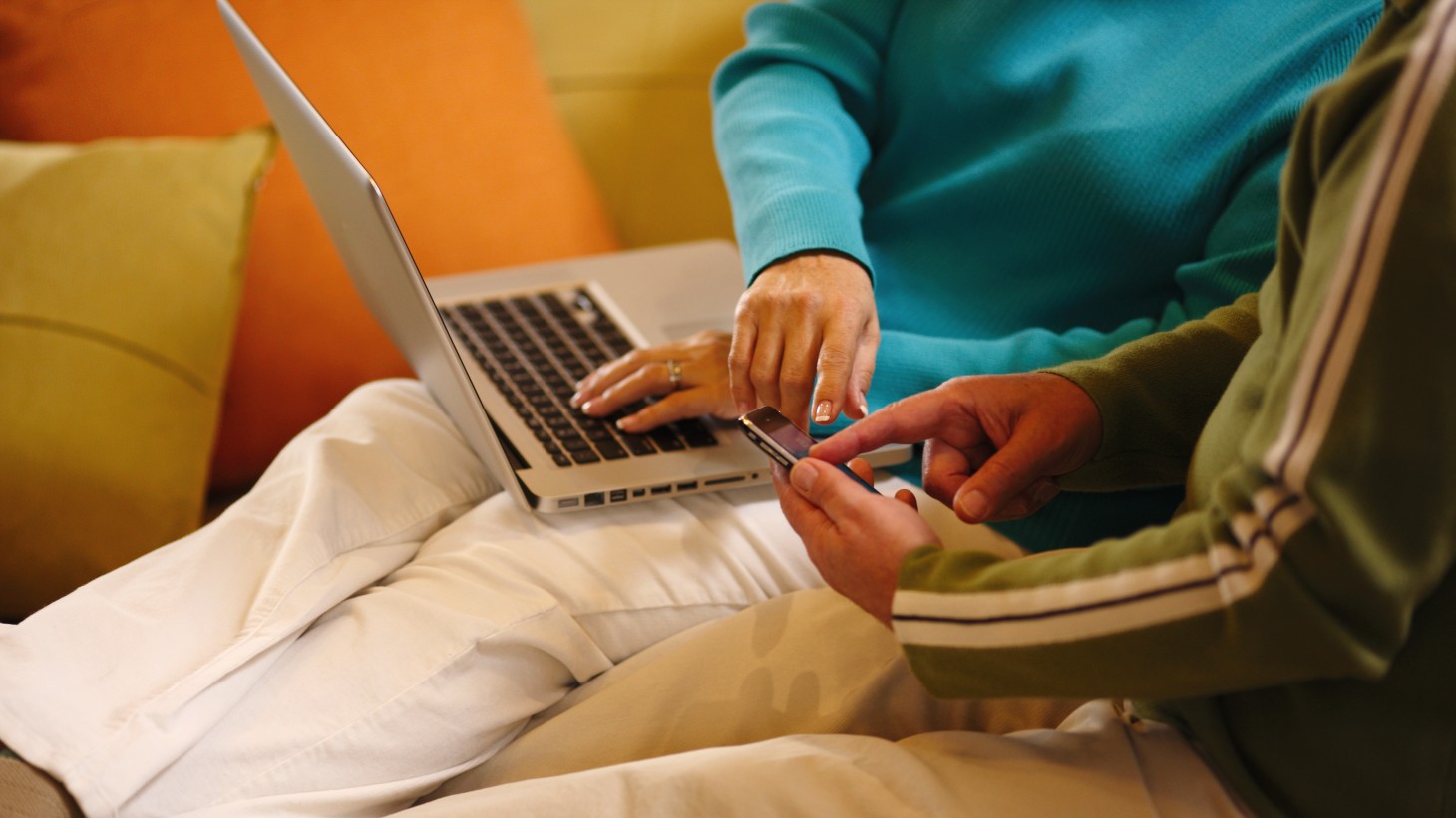 hands at a laptop and a smartphone 