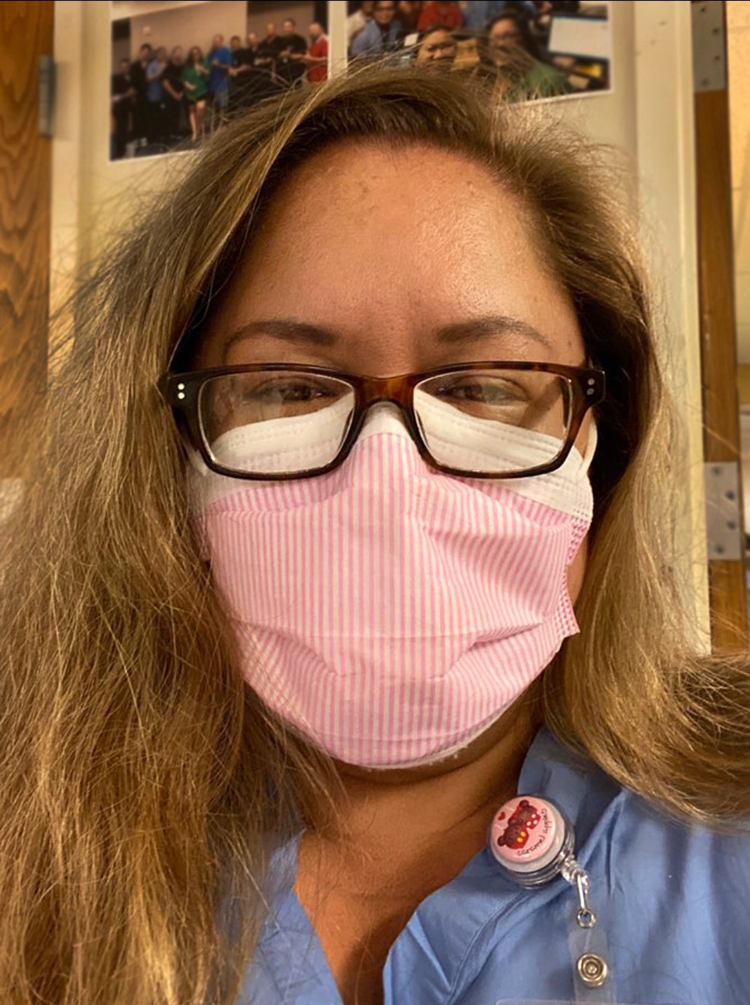 Woman with long hair wearing pink cloth mask 