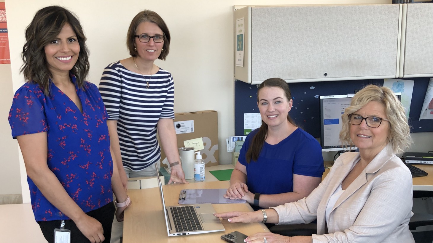 Four women smiling in office