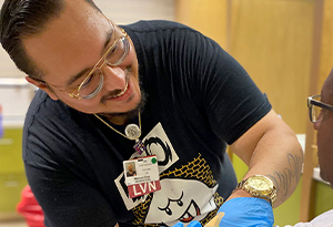 smiling man leaning forward with glove on