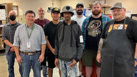 Group portrait of 8 men inside a room