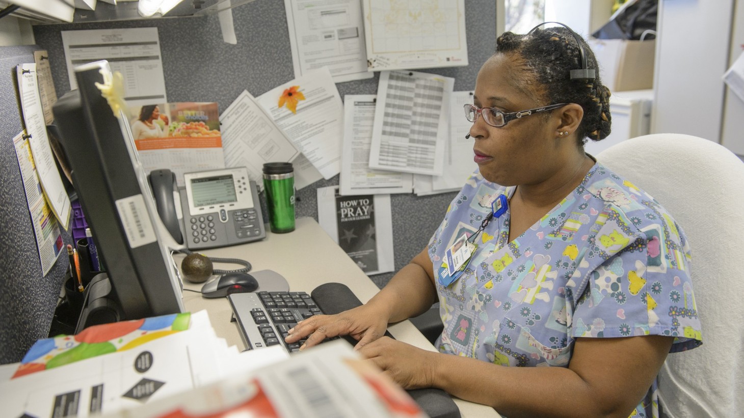 Nurse typing and looking at a computer screen 