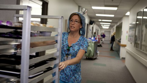 Nutrition aide pushing a cart of meals