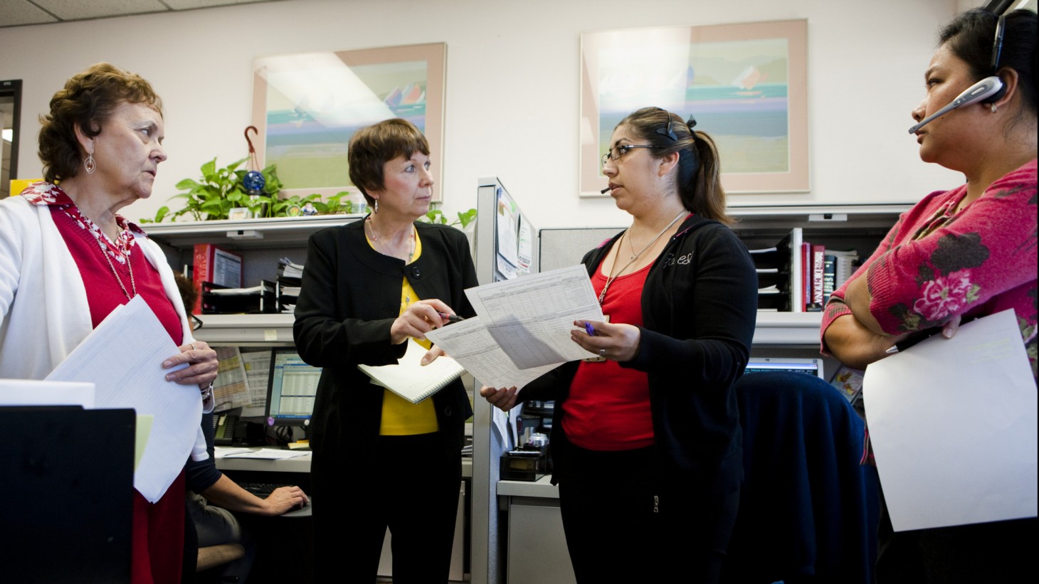 Four female health care workers standing in their morning huddle 